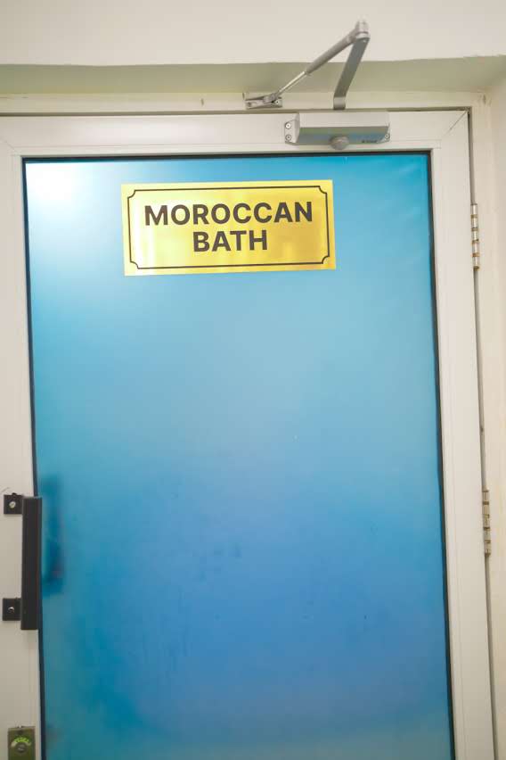 Moroccan Bath — blue frosted glass door with gold plaque